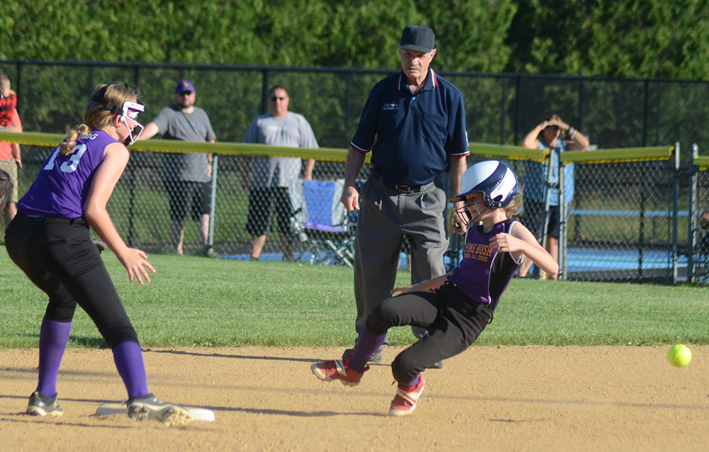 Pine Bush-Monticello’s Amelia Bavolar slides into second base as Warwick-Greenwood Lake shortstop Emily Romig waits for the throw during Wednesday’s District 18 major softball championship game at Pine Bush Little League field.